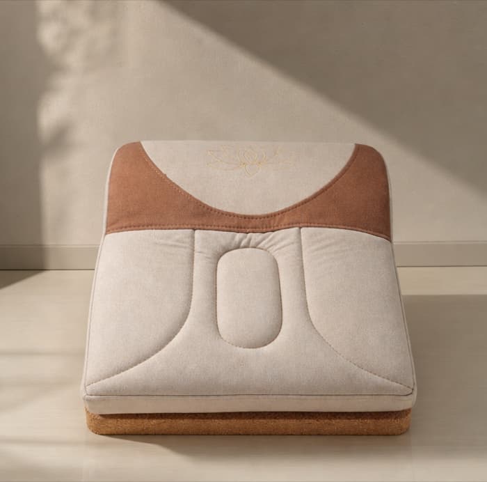 The Lotus Seat: a cream cotton-linen meditation seat with a terracotta back panel and gold lotus, on a solid cork base