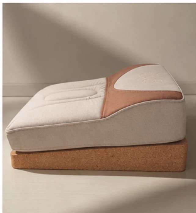 Side view of the Lotus Seat, rising from a thin front edge up to a higher back over its cork base